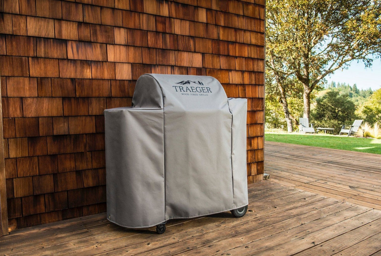 Full-length gray Traeger grill cover protecting outdoor grills from weather in lawn and garden setting