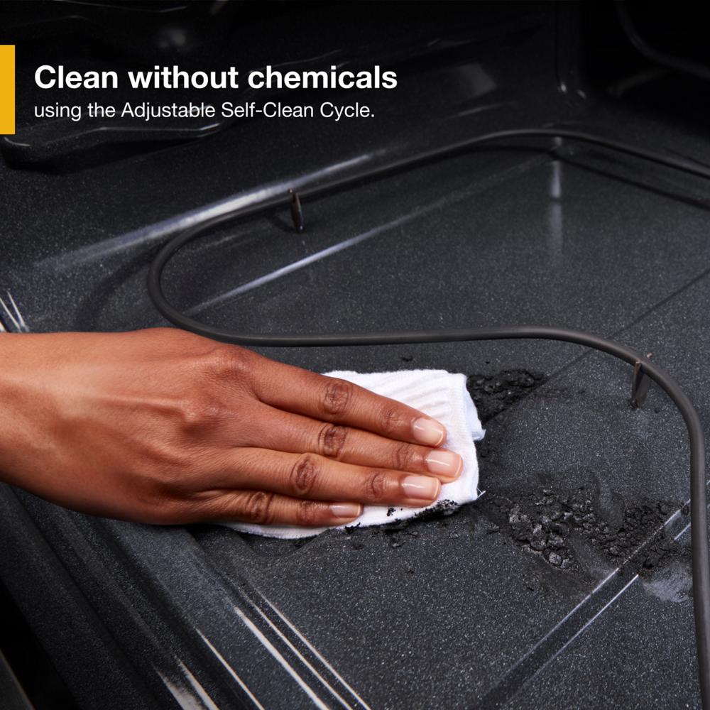 Hand wiping oven interior showcasing adjustable self-clean cycle feature for chemical-free cleaning in kitchen appliances collection