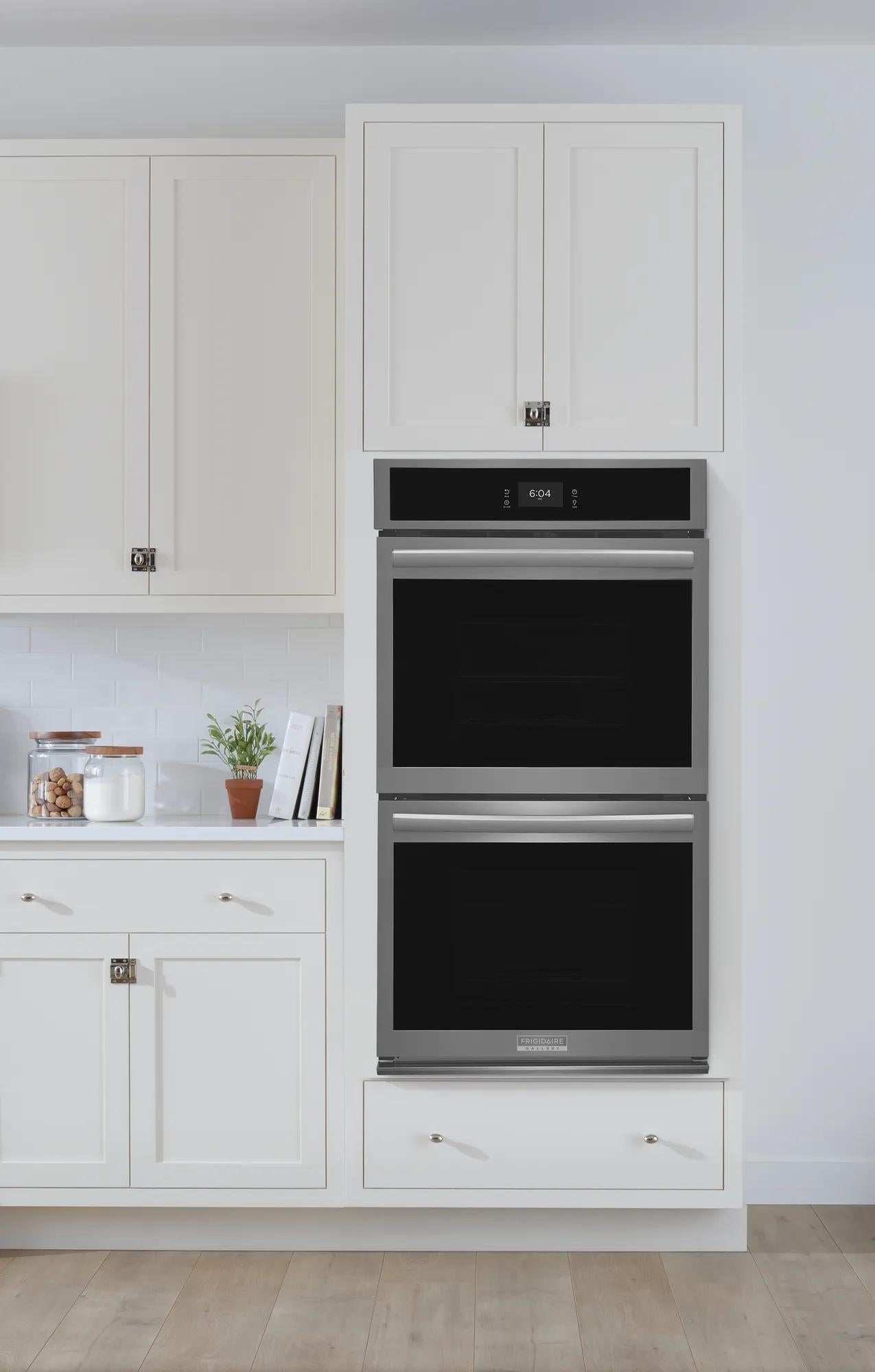 Built-in stainless steel double wall oven with digital display in a modern white kitchen setting from Appliances and Kitchen collections