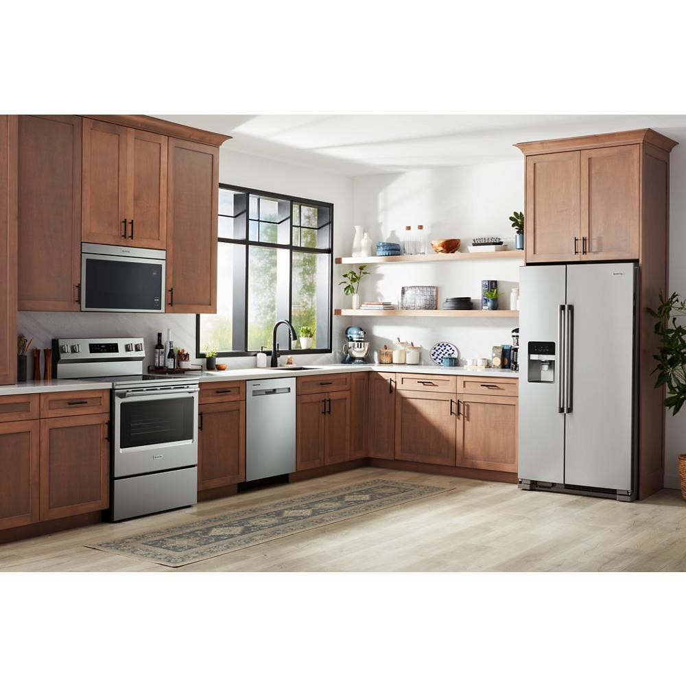 Modern kitchen featuring stainless steel appliances including electric range, dishwasher, microwave, and side-by-side refrigerator