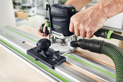 Compact Festool woodworking router in use with guide stop and dust extraction for precise home improvement tasks