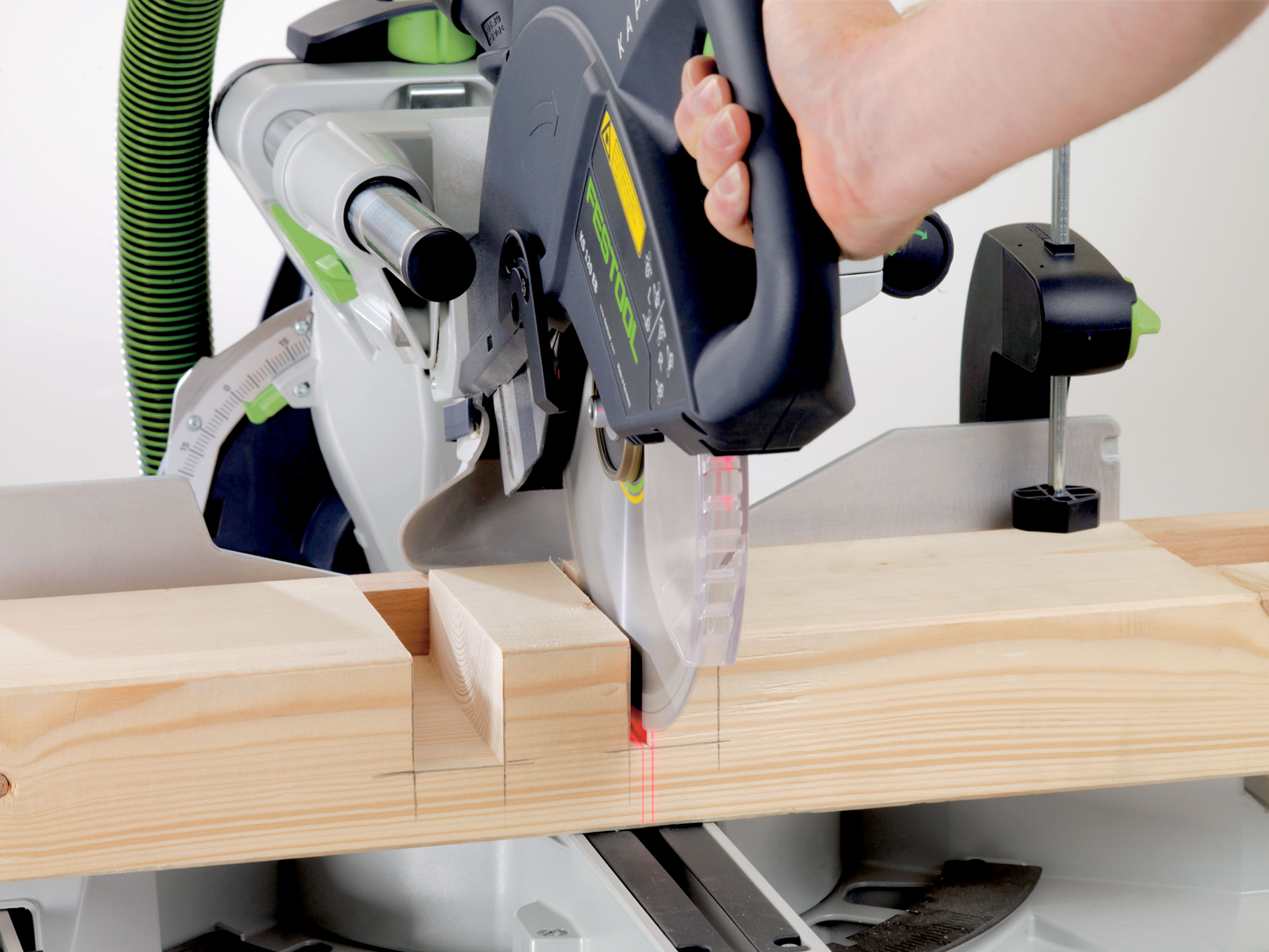 Hand operating Festool sliding compound miter saw making precise wood cuts in Power Tools and Saws collections