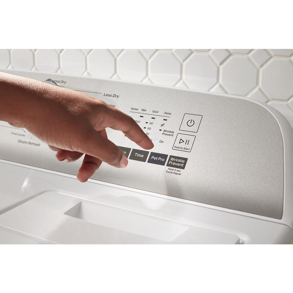 Finger pressing Pet Pro option on silver control panel of top load electric dryer in laundry room setting
