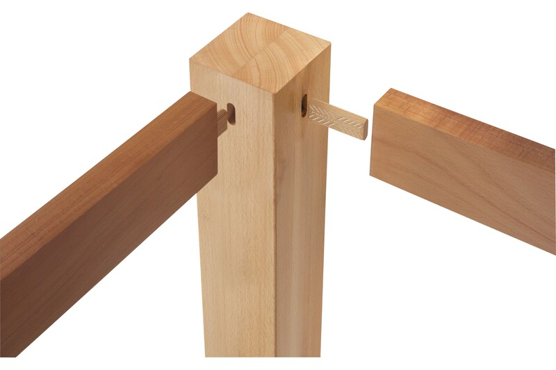 Close-up of beech wood tenon joint connecting three light-colored wooden pieces for woodworking tools collection