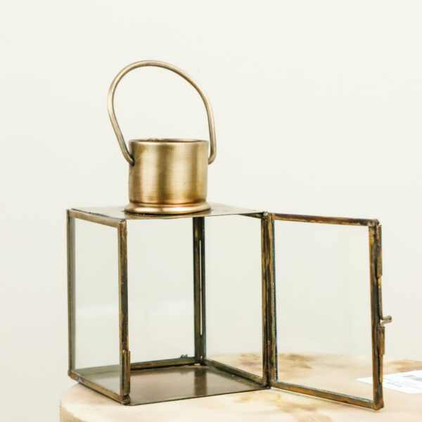 Brass and glass lantern with hinged door and rounded handle for home and garden lighting accessory use