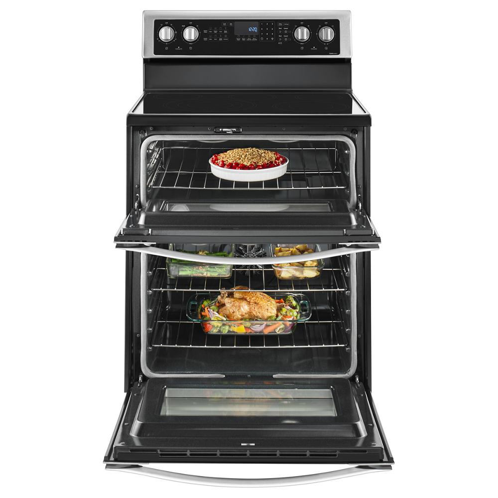 Open electric range with two ovens cooking casserole and roasted chicken with vegetables on racks from kitchen appliances collection