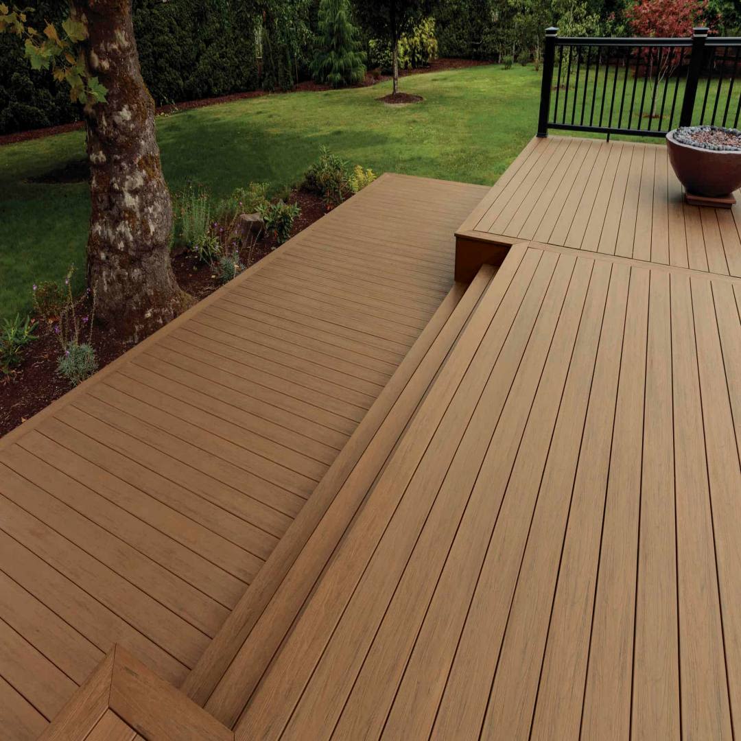 Outdoor composite decking with antique leather finish riser board and landscaped garden in the background
