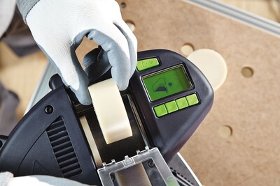 Hand in glove loading natural EVA edge banding roll into power tool for woodworking and home improvement tasks