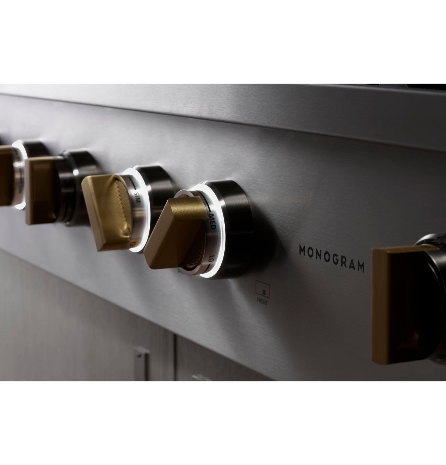Close-up of metallic cooktop knobs with backlit lighting on stainless steel appliance in kitchenware and appliances collections