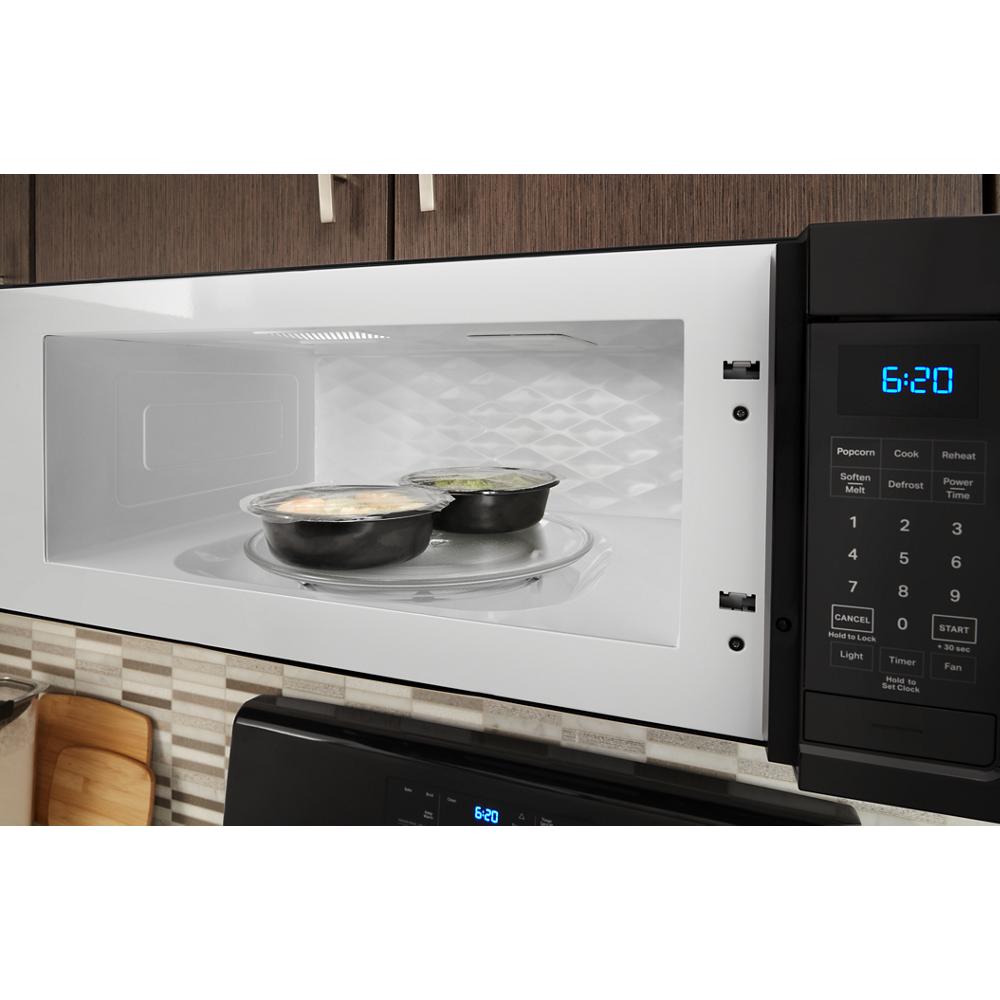 Open white low profile microwave hood with digital keypad and two bowls of food inside in kitchen setting