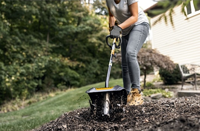 Person using DEWALT cultivator attachment on soil in outdoor garden setting from Dewalt Outdoor Power collection