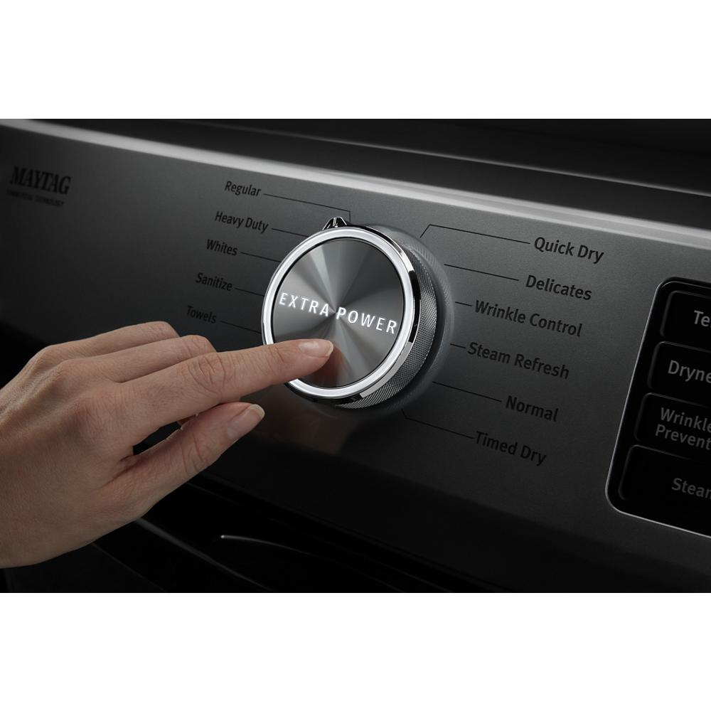 Hand pressing metallic control knob labeled Extra Power on dryer panel with cycle options in home appliances collection