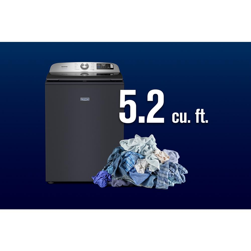 Dark gray top load washer with digital controls and 5.2 cu. ft. capacity next to a pile of clothes in washers collection