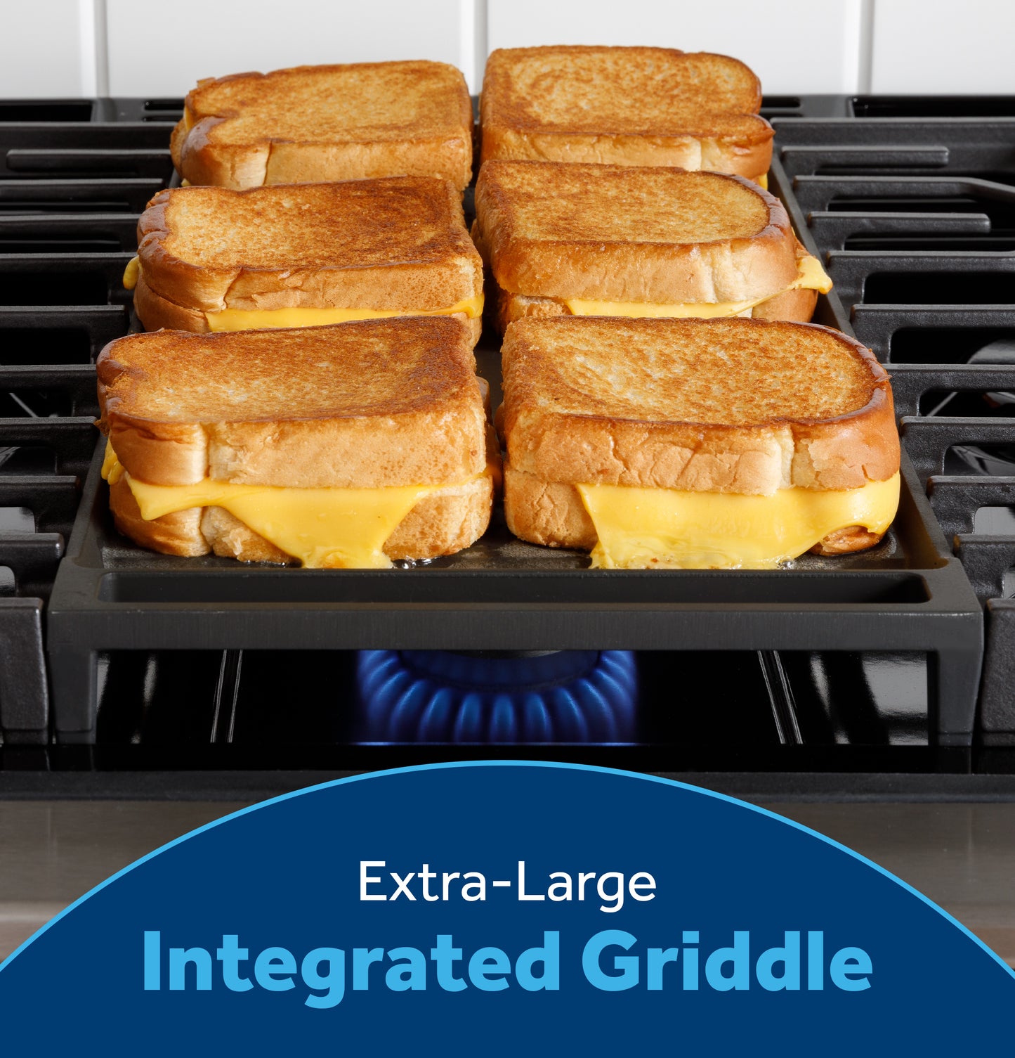 Six melted cheese grilled sandwiches cooking on an extra-large integrated griddle over a front-control gas range flame