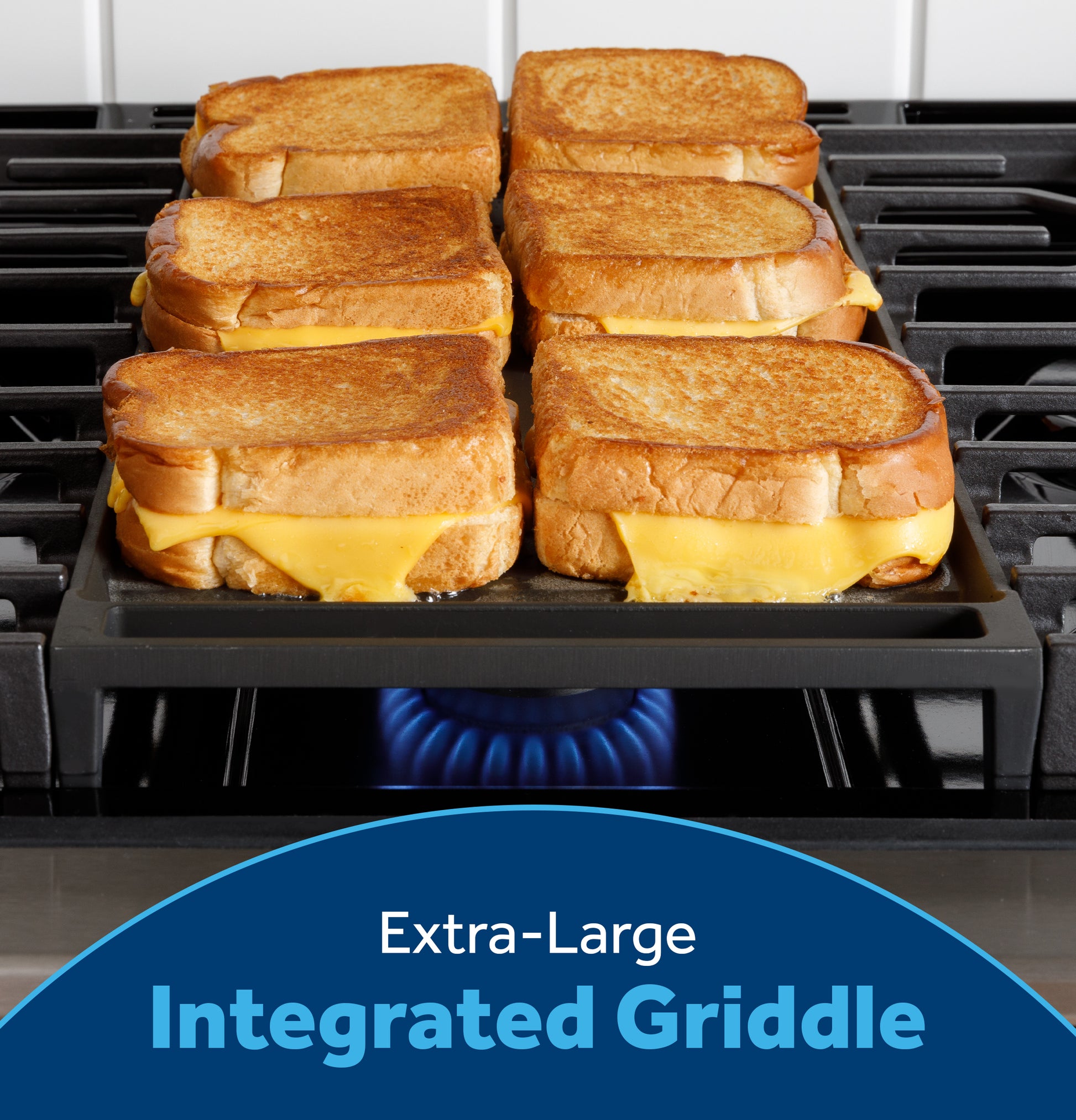 Six melted cheese grilled sandwiches cooking on an extra-large integrated griddle over a front-control gas range flame