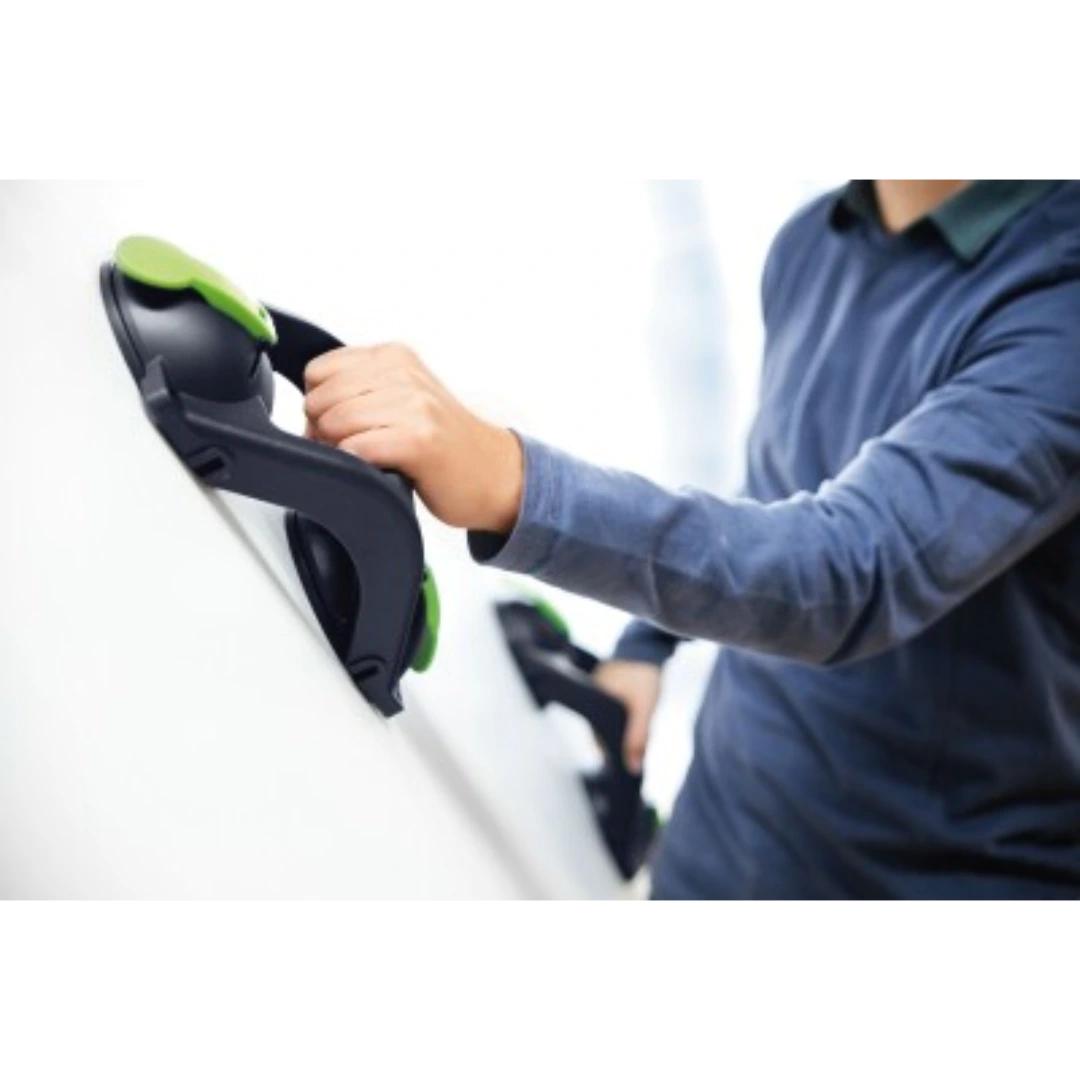 Person using Festool suction handle with green quick-release levers to lift smooth panel in woodworking tool accessories collection