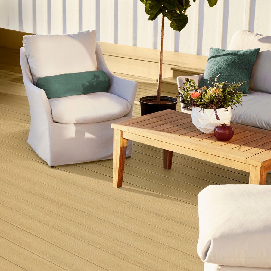 Outdoor seating area featuring grooved natural white oak composite decking and cozy cushioned chairs for home improvement