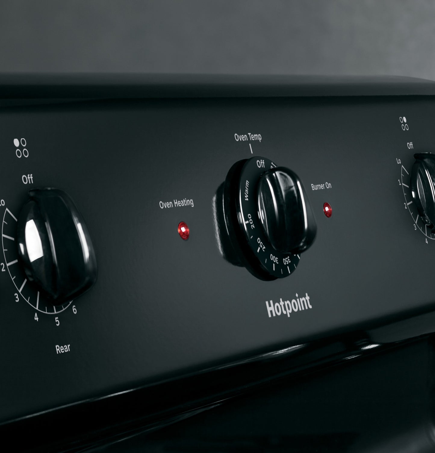 Close-up of black control panel with temperature and burner knobs on Hotpoint free-standing electric range from Ranges collection