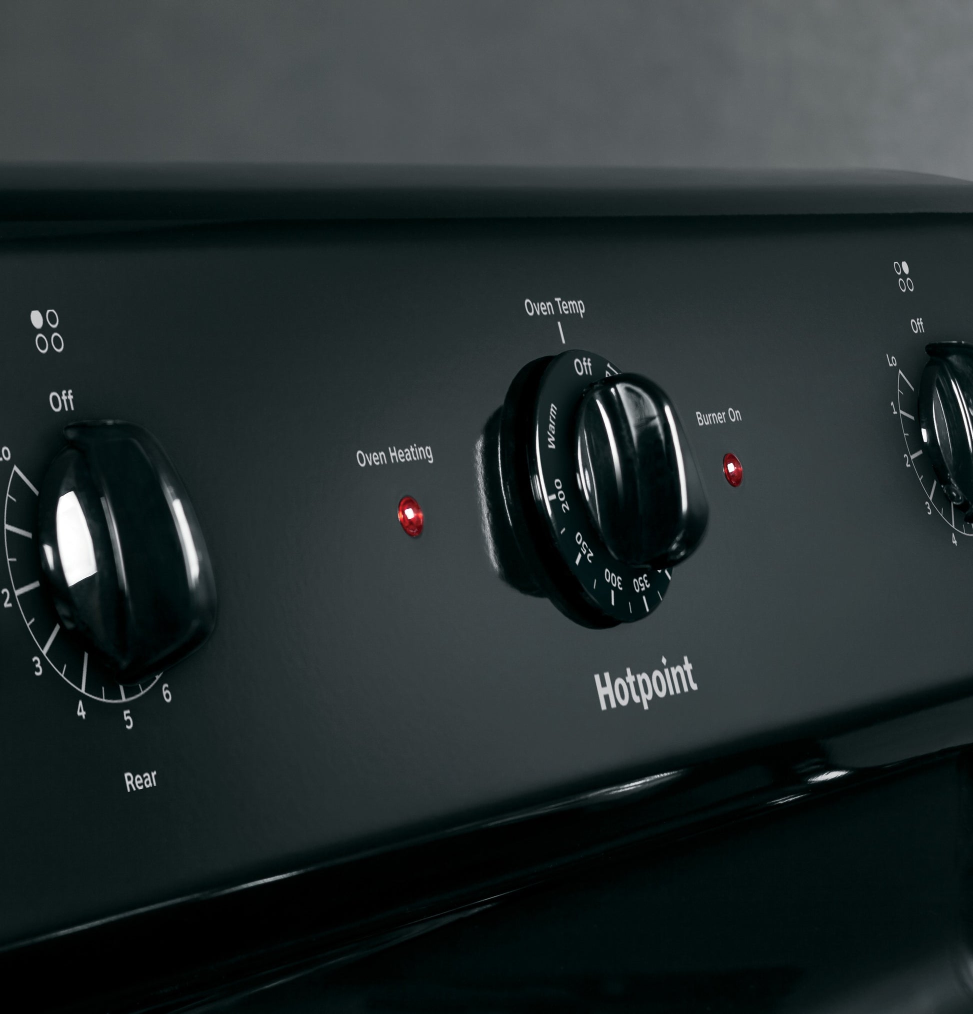 Close-up of black control panel with temperature and burner knobs on Hotpoint free-standing electric range from Ranges collection