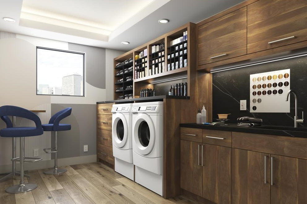 Laundry area featuring white front-load washer and dryer surrounded by dark wood cabinetry and shelves from Dryers collection