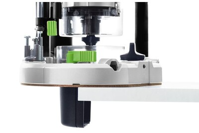 Close-up of Festool router base with green adjustment controls positioned on edge of wood plank in woodworking tools collection