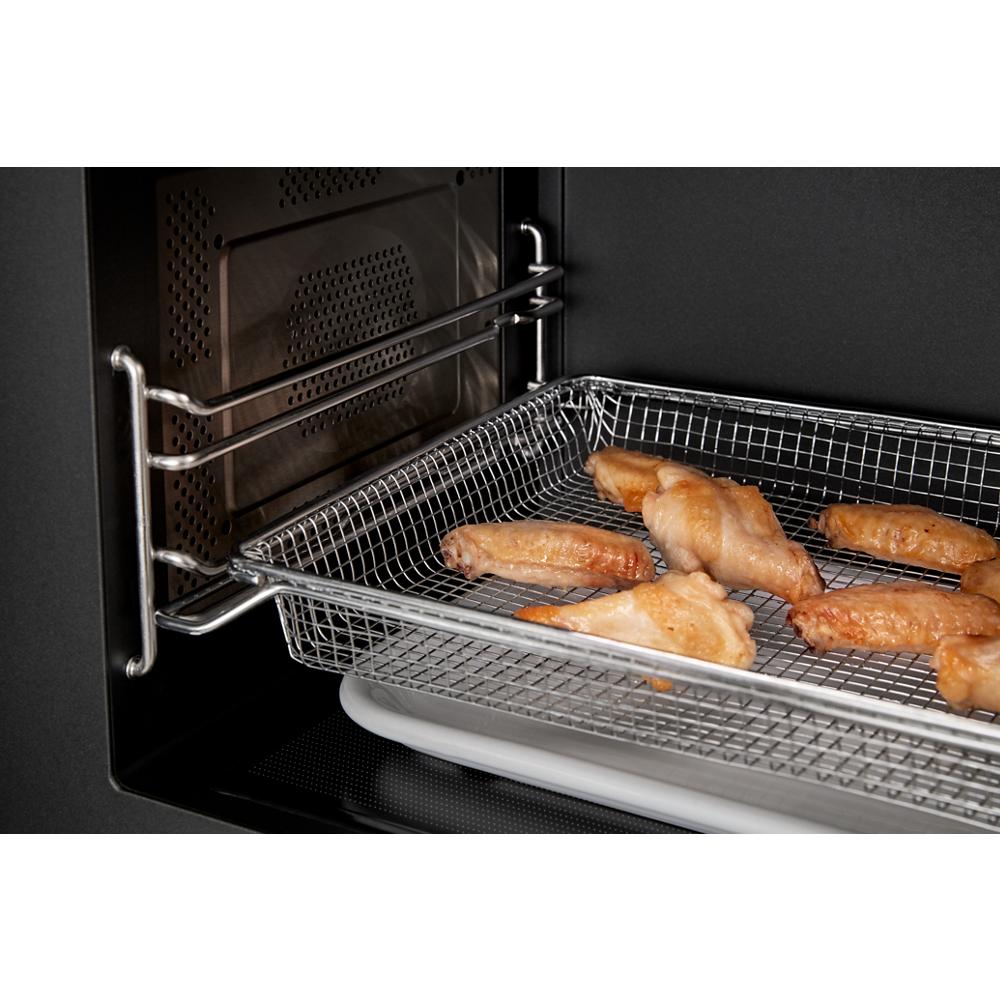 Crisping chicken wings in wire air fry basket inside an oven from kitchen and kitchenware collection