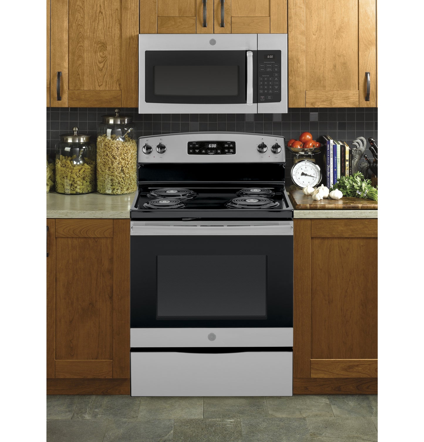 Stainless steel microwave above electric coil range with control panel, set in wood cabinets for kitchen appliances collection