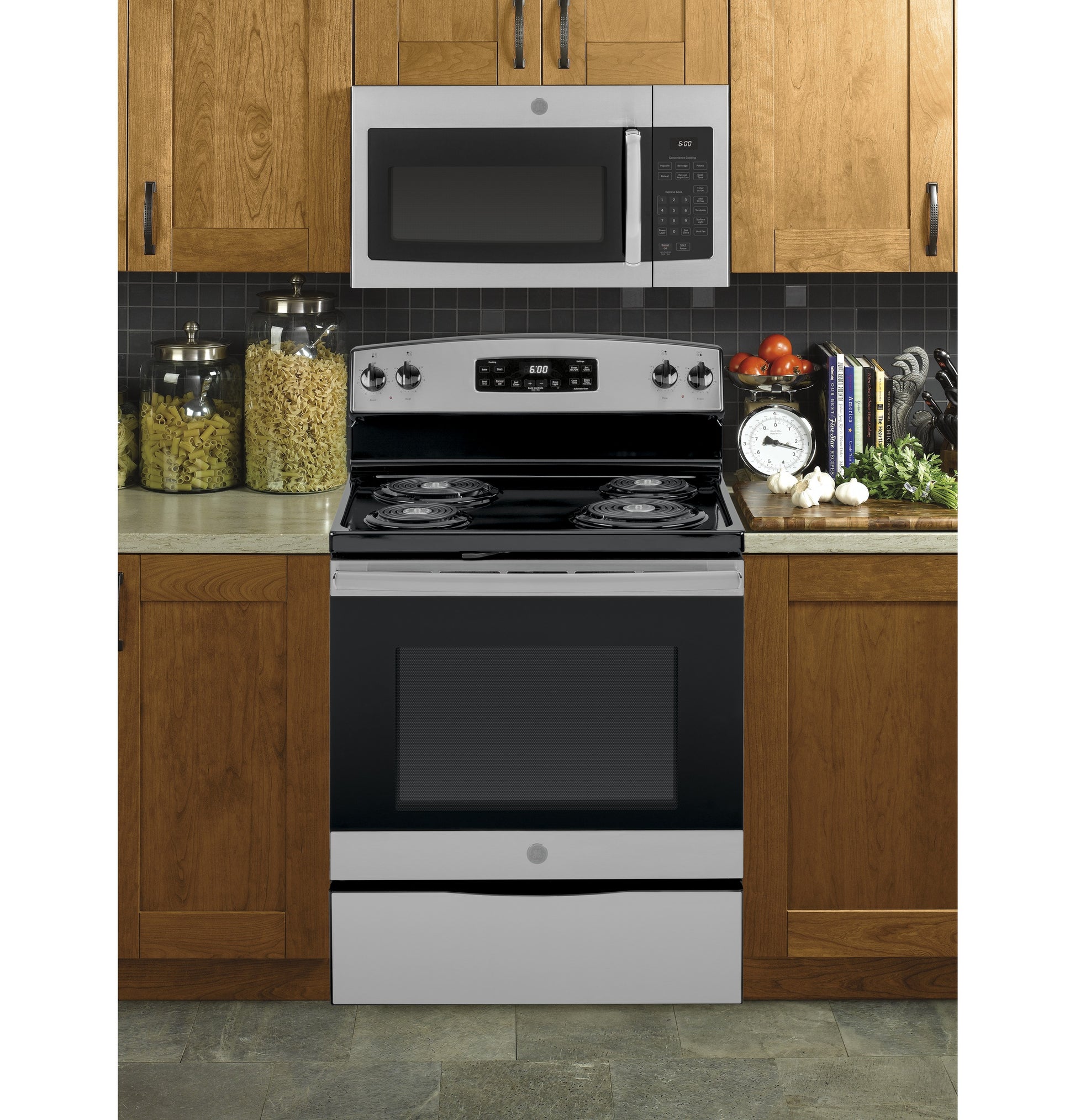 Stainless steel microwave above electric coil range with control panel, set in wood cabinets for kitchen appliances collection