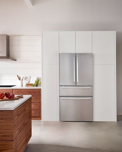 Built-in style stainless steel French door refrigerator with bottom freezer in modern kitchen setting for home improvement.