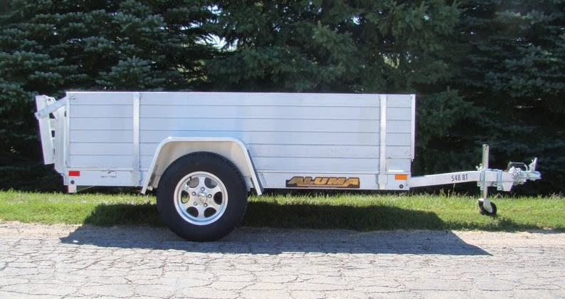 Aluminum flatbed trailer side rack set with solid panels designed for hauling and home improvement tasks