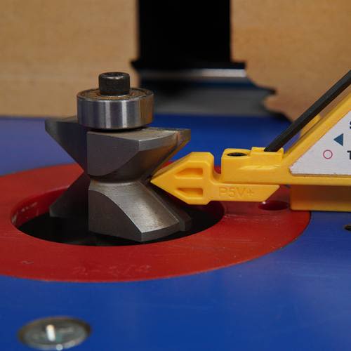 Close-up of a metal woodworking router bit with a yellow plastic guide tool for precision in saw accessories and tool upgrades.