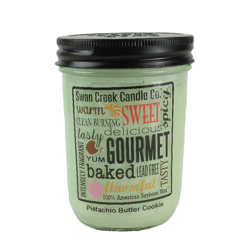 Green glass jar candle with black lid labeled Pistachio Butter Cookie and decorative word art on front