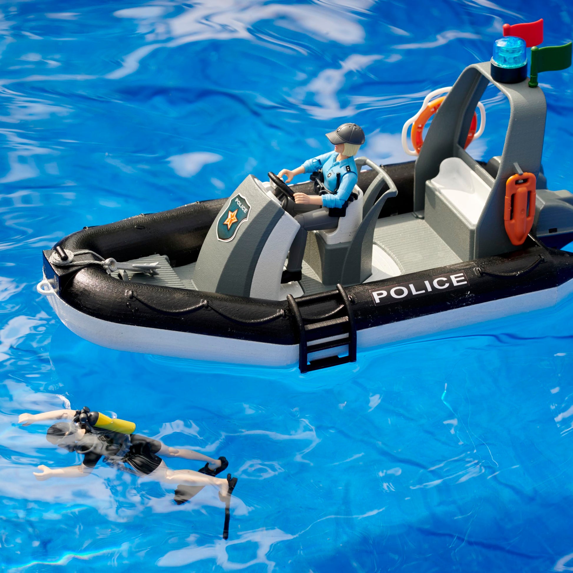 Police inflatable boat toy with officer figure and diver figure in blue water from Bruder Toys collection