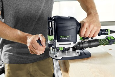 Person using a Festool woodworking tool with dust extraction for precise wood shaping in home improvement projects