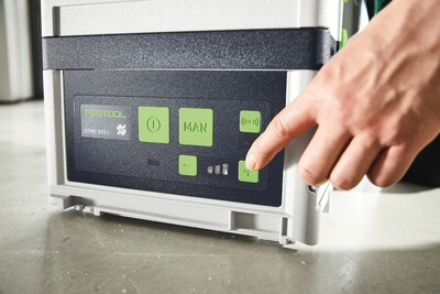Person pressing button on control panel of cordless dust extractor for woodworking and air filtration tools
