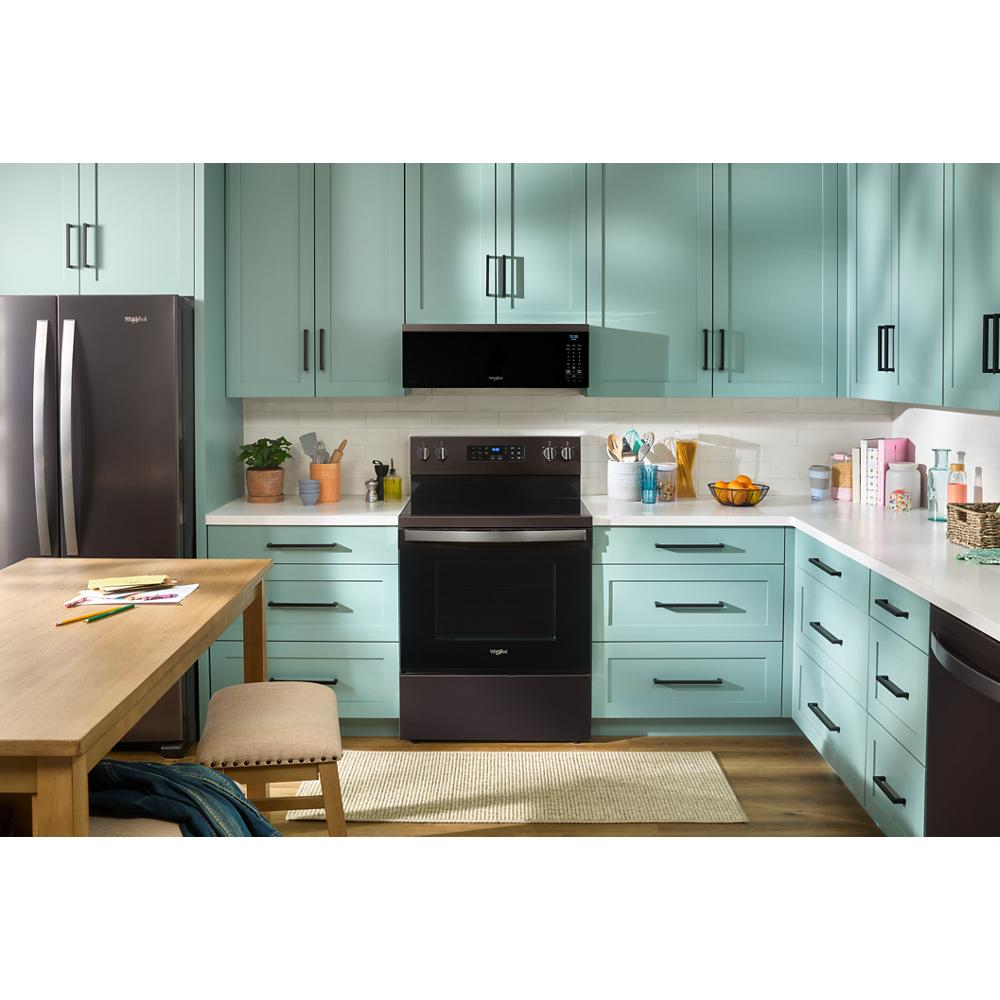 Modern kitchen with black microwave hood vent above range, teal cabinetry, and matching black Whirlpool refrigerator and oven