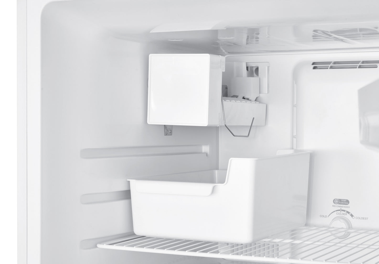 Automatic ice maker kit installed inside top freezer refrigerator with ice storage bucket and wiring components.