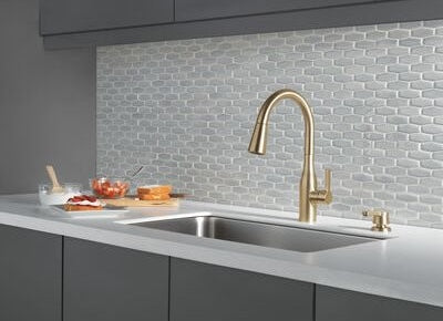Modern champagne bronze kitchen faucet with high-arc spout and integrated soap dispenser in a contemporary kitchen setting