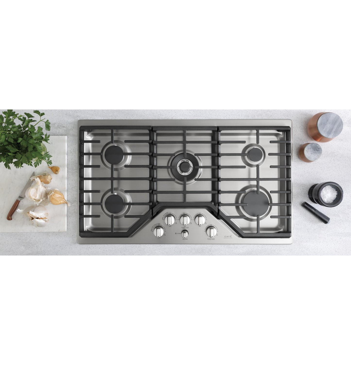 Stainless steel 36-inch gas cooktop with five burners and control knobs in modern kitchen appliances collection