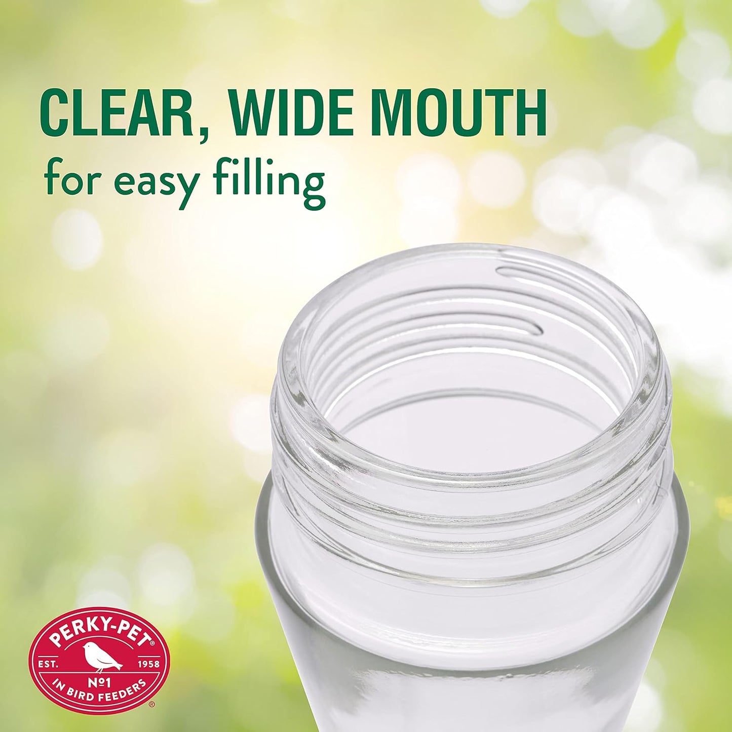 Close-up of a clear glass hummingbird feeder with a wide mouth for easy filling against a green outdoor backdrop