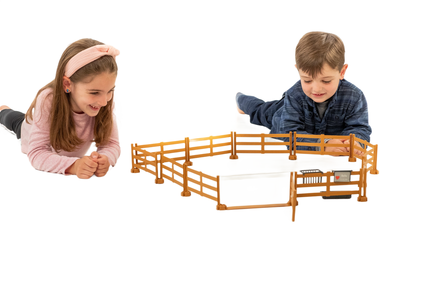 Two children playing with a brown plastic pasture fence toy from Bruder in the Toys & Games collection under $50