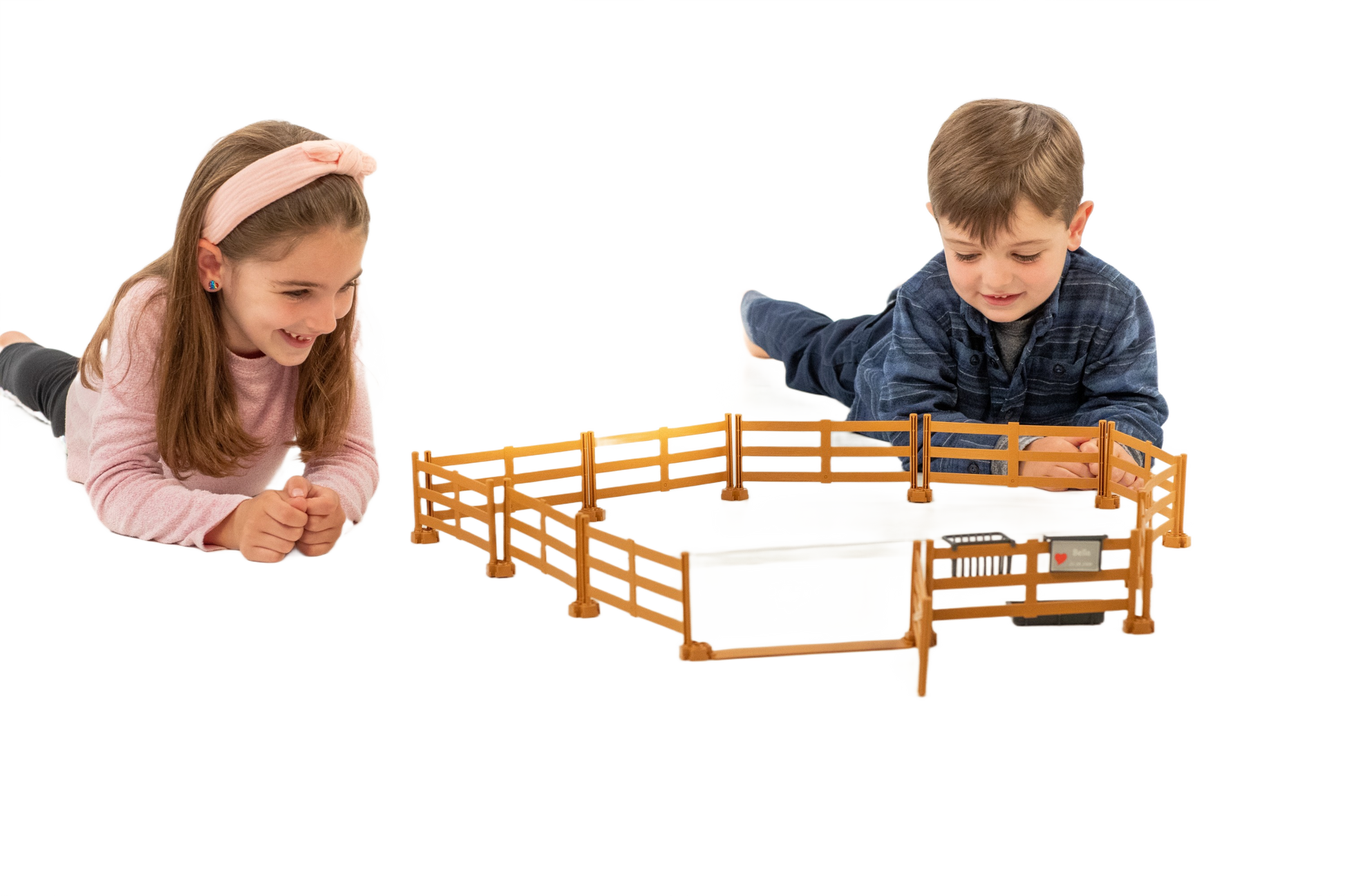 Two children playing with a brown plastic pasture fence toy from Bruder in the Toys & Games collection under $50