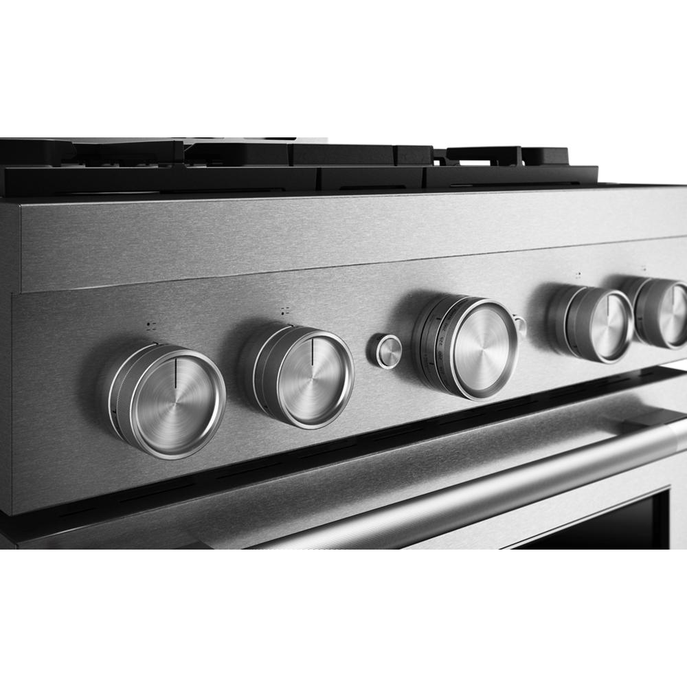 Close-up of stainless steel control panel with brushed metal knobs on commercial-style gas range from Kitchen & Kitchenware collection
