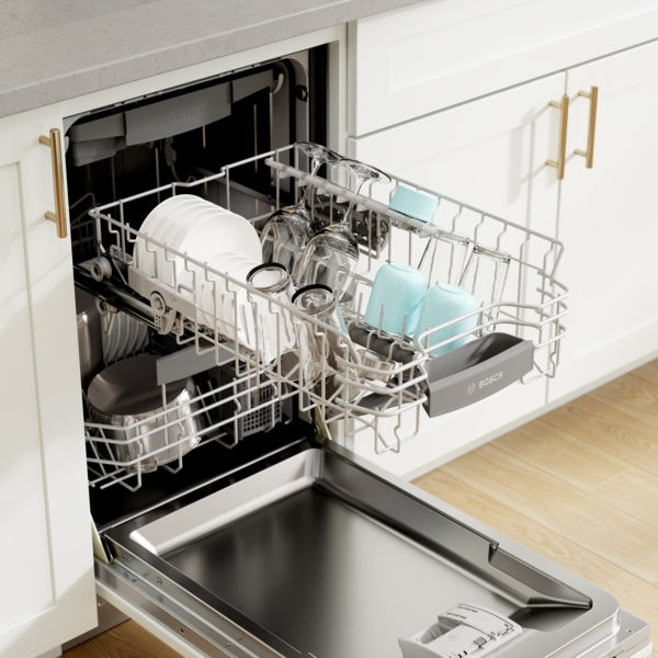 Open Bosch dishwasher with upper rack holding glasses and cups and lower rack loaded with plates and pots in kitchen setting
