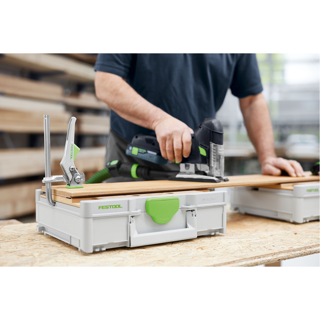 Person using a Festool jigsaw on a lightweight modular work surface with integrated clamp, designed for woodworking and tool storage.