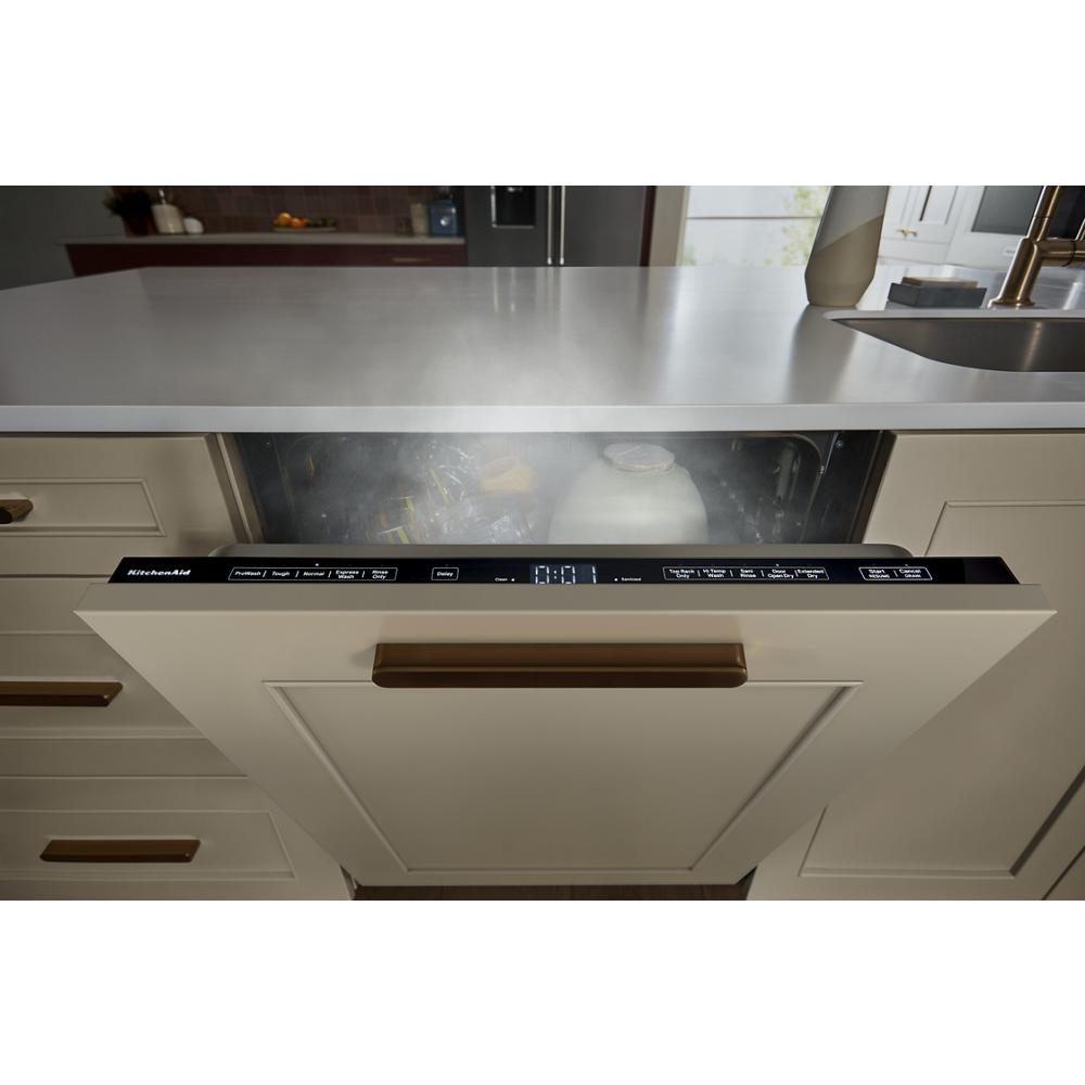 Steam rising from an open panel-ready dishwasher integrated into beige cabinetry in the KitchenAid appliances collection