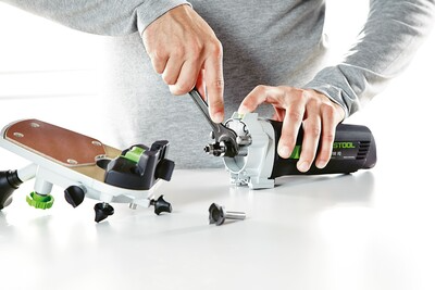 Person assembling a Festool trim router set with green accents for precise home improvement tool use