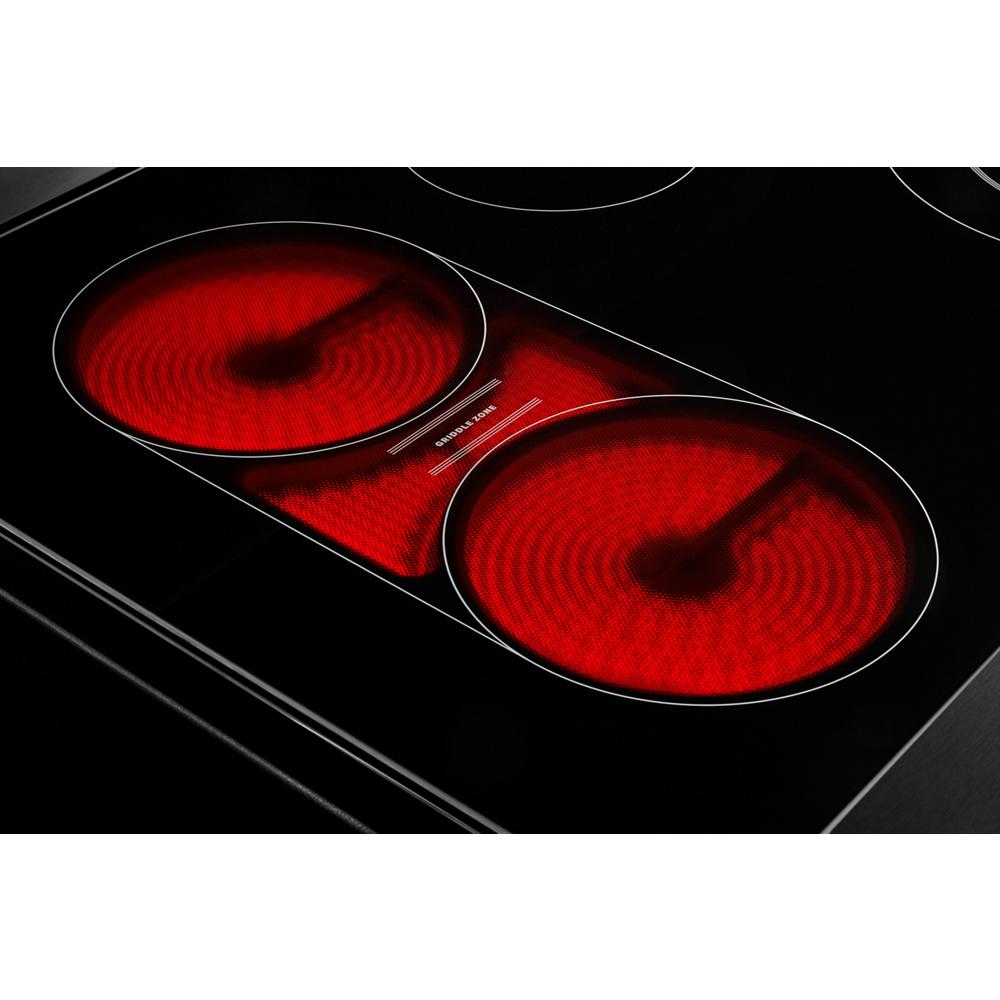 Close-up of glowing red electric cooktop burners on black smooth surface from ranges and kitchen appliances collection