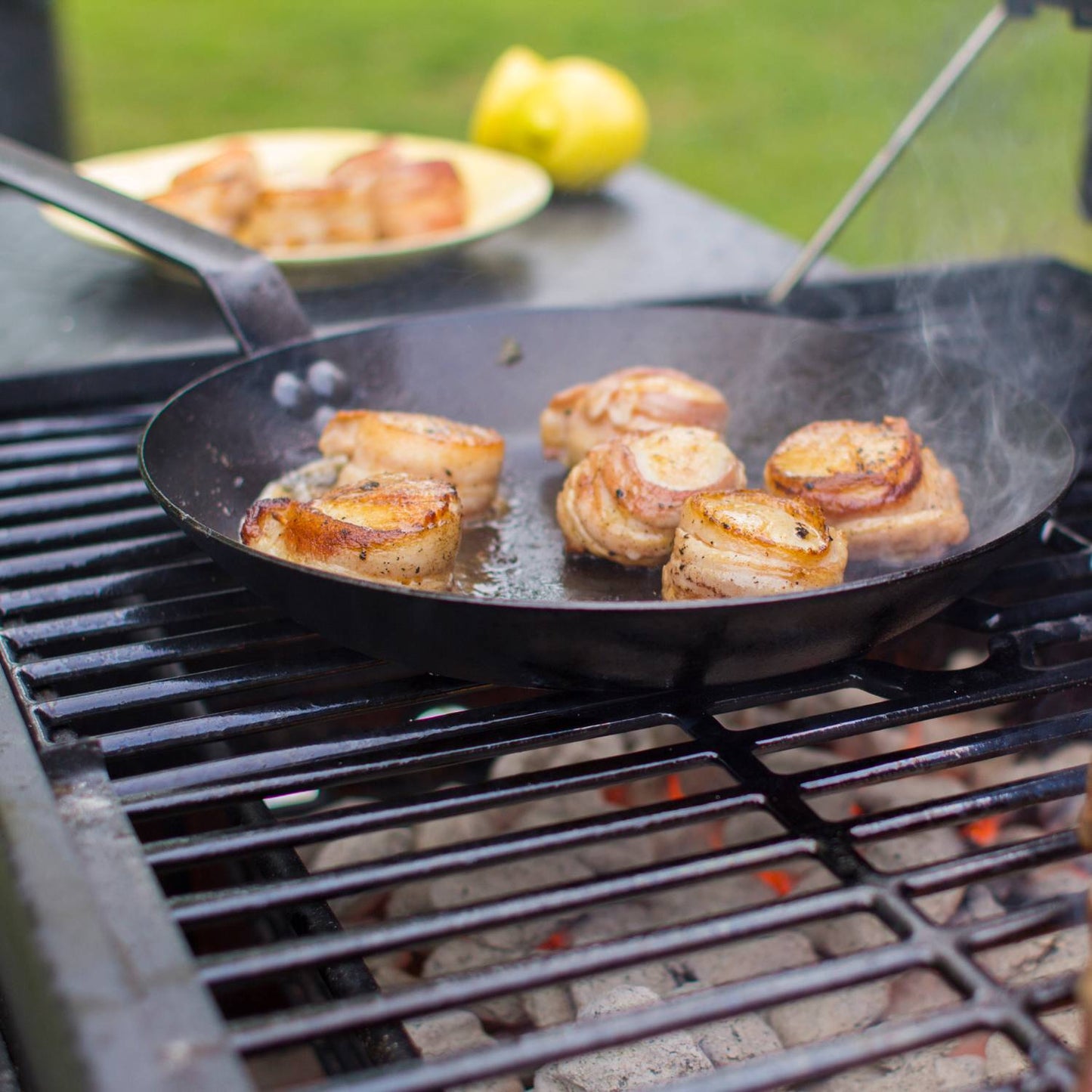 Seasoned 12 gauge steel skillet cooking bacon-wrapped scallops on outdoor grill in kitchenware under $100 collection