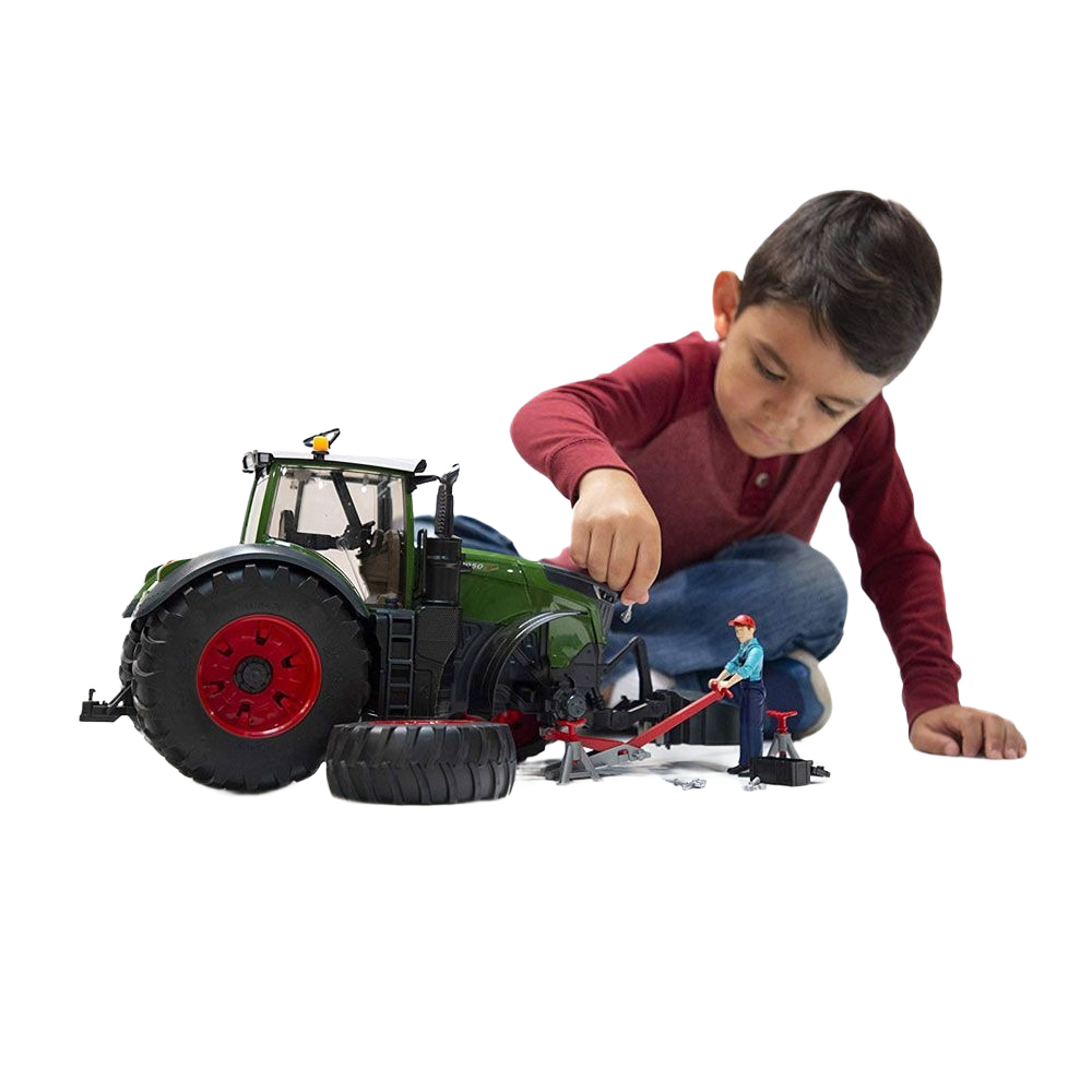 Young boy assembling a green toy tractor with detachable large tires and miniature repair accessories for play and learning